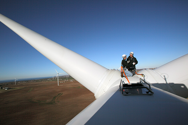 Two technicians servicing a wind power turbine